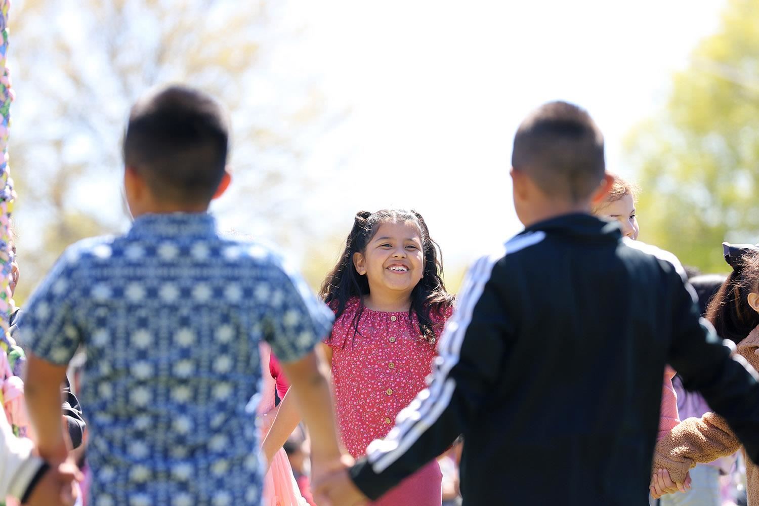 Smiling students at the outdoor May Day dance at Howard Elementary.